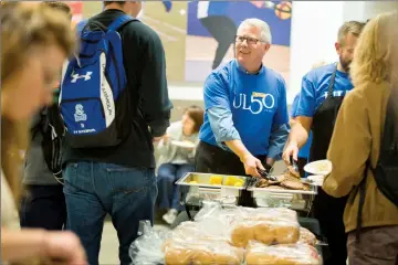  ?? Herald photo by Ian Martens ?? University of Lethbridge president Mike Mahon helps serve up burgers as during a welcome-back barbecue this week on campus. @IMartensHe­rald