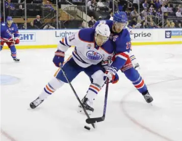  ??  ?? NEW YORK: Anton Lander #51 of the Edmonton Oilers is checked by Ryan McDonagh #27 of the New York Rangers during the third period at Madison Square Garden on Thursday in New York City. The Rangers defeated the Oilers 5-3. — AFP