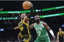  ?? STEVEN SENNE — THE ASSOCIATED PRESS ?? Warriors forward Jonathan Kuminga (00) grabs the ball in front of Boston Celtics guard Jaylen Brown (7) in the first half Sunday in Boston.