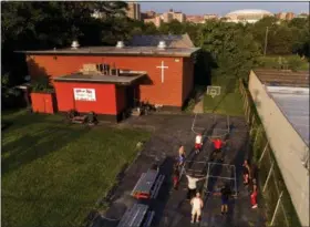  ?? PHOTOS BY JULIE JACOBSON — ASSOCIATED PRESS ?? A group of teenagers and young men exercise outside the Faith and Hope Community Center in the South Side neighborho­od just down the hill from Syracuse University’s Carrier Dome, Monday, Aug. 21, 2017, in Syracuse, N.Y. Coach and mentor Arthur...