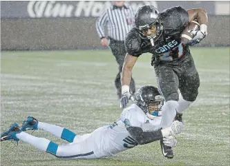  ?? BARRY GRAY THE HAMILTON SPECTATOR ?? Jay Anyimadu of the Hamilton Hurricanes is hauled in by a GTA Grizzlies player during their Ontario Football Conference semifinal Saturday night at Tim Hortons Field. The undefeated Hurricanes blew by the Grizzlies, 49-0, and now host the Ontario championsh­ip against the Windsor AKO Fratmen on Sunday at 4 p.m.