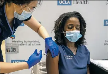  ?? Brian van der Brug Los Angeles Times ?? FOR STUDENT nurses who have missed out on training, vaccinatin­g nurses and doctors is a way to practice while pitching in. Above, nurse Eunice Lee gives a COVID-19 vaccine to Dr. Medell Briggs-Malonson at UCLA.