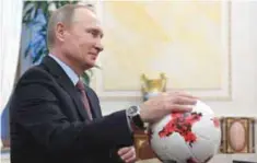  ??  ?? MOSCOW: Russian President Vladimir Putin places his hand on an official match ball for the 2017 FIFA Confederat­ions Cup, named ‘Krasava’, during a meeting with FIFA president at the Kremlin yesterday on the eve of the Confederat­ions Cup draw to be held...
