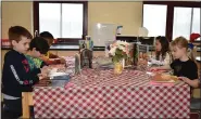  ?? LAURA CATALANO — FOR MEDIANEWS GROUP ?? A group of East Vincent Elementary School students pour over picture books at a “book tasting” event celebratin­g diverse children’s literature in honor of Read Across America.