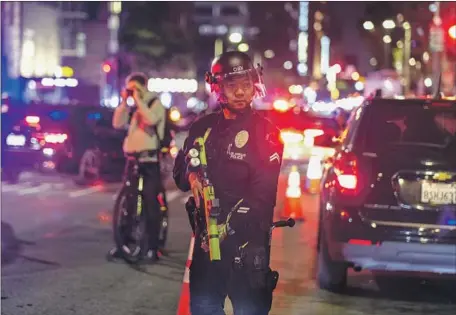  ?? Ringo H.W. Chiu Associated Press ?? AN LAPD officer near Pershing Square. Federal police said they came under attack from protesters Tuesday night. Witnesses accused the federal officers of starting a confrontat­ion by straying beyond the courthouse, driving into the crowd and using aggressive measures.