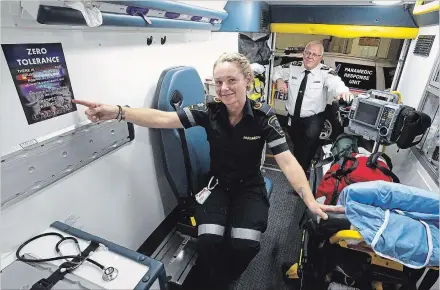  ?? CLIFFORD SKARSTEDT EXAMINER ?? Paramedic Stephanie Duggan next to a zero tolerance for violence against paramedics ambulance sticker, with Paramedics Chief Randy Mellow.