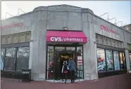  ?? ZACH GIBSON/BLOOMBERG ?? People walk into a CVS Health Corp. store in Washington, D.C., in December.