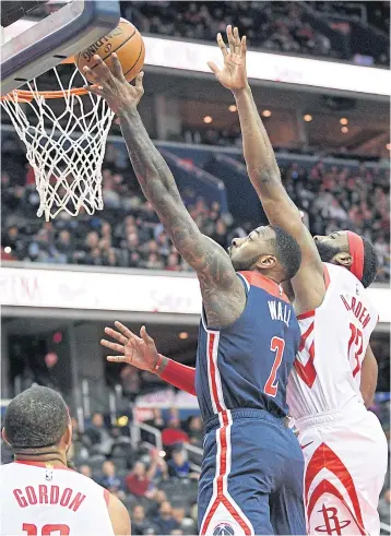  ?? AP ?? The Wizards’ John Wall, No.2, goes to the basket against the Rockets’ James Harden in Washington.