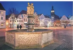  ?? FOTO: PATRICK PLEUL/DPA ?? Der Altmarkt der Stadt Cottbus ist am Abend zur blauen Stunde beleuchtet.