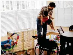  ?? COURTNEY HERGESHEIM­ER PHOTOS / COLUMBUS DISPATCH ?? Matt Weisgarber sets son Donovan down to play. Donny — as his dad calls him — recently had his first Little League baseball game.