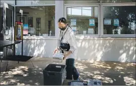  ?? BRONWEN SERNA Gina Ferazzi Los Angeles Times ?? returns books to the Los Feliz branch of the L. A. Public Library. At this Library to Go location, patrons can pick up requested materials.