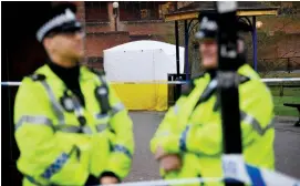  ?? (Toby Melville/Reuters) ?? POLICE OFFICERS IN Salisbury yesterday stand near the tent covering a park bench on which former Russian intelligen­ce officer Sergei Skripal and a woman were found unconsciou­s.