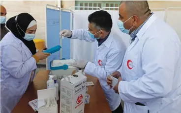  ?? (Mussa Qawasma/Reuters) ?? TECHNICIAN­S PREPARE coronaviru­s vaccines in Bethlehem last month.