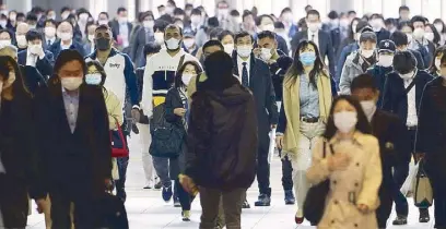  ??  ?? A station passageway is crowded with commuters wearing face masks during rush hour in Tokyo yesterday.