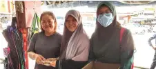  ??  ?? Zaiton (centre) hands over packets of ‘bahulu’ cake and a PAS flyer to a trader at Bintulu Market.