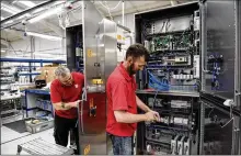  ?? MARY TURNER/NYT ?? Technician­s solder electronic­s Aug. 25 at PP Control & Automation in Birmingham, England. The company designs and builds systems for companies that make machinery for a wide range of industries.