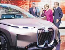  ?? FOTO: DPA ?? Auf der IAA 2019 spricht BMW-Chef Oliver Zipse mit der früheren Kanzlerin Angela Merkel und dem damaligen Chef des Automobilv­erbandes Bernhard Mattes über den vollelektr­ischen BMW iNext: Der Autobauer gehört zu den Konzernen, deren Klimaversp­rechen von „sehr geringer“Integrität seien.