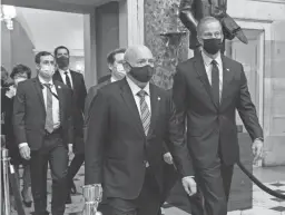  ?? AP ?? Sen. Mark Kelly, D-Ariz., left, and Sen. John Thune, R-S.D., walk Wednesday with fellow senators in a procession that carried boxes of Electoral College votes.