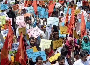  ?? AFP ?? Workers hold placards as they march during a May day rally in Lahore on Wednesday. —