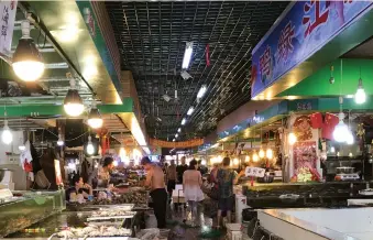  ?? (Philip Wen/Reuters) ?? CUSTOMERS SELECT seafood at a wet market in Dandong, Liaoning province, China, earlier this week.