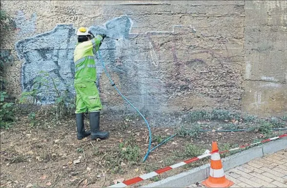  ?? MARC ARIAS ?? Israel, uno de los operarios que se dedican a borrar grafitis de fachadas y paredes, ayer en plena faena en el distrito de Sants-Montjuïc