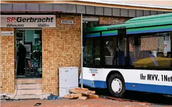  ?? FOTO: DPA ?? Der Bus ist frontal in ein Elektrofac­hgeschäft gekracht. Im Inneren waren Sitzbänke nach vorne geklappt. Es wird geprüft, ob das Gebäude einsturzge­fährdet ist.