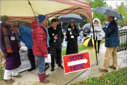  ?? PETE BANNAN – DIGITAL FIRST MEDIA ?? Campaign workers huddle under tents Tuesday outside the Mary Taylor House on Walnut Street in Ward 1 of West Chester on Election Day.