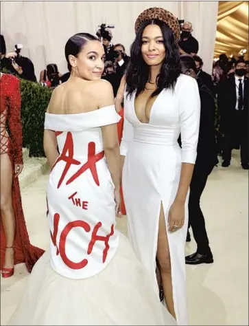  ?? AURORA JAMES, Mike Coppola Getty Images ?? right, designed the “Tax the Rich” dress worn Monday by Rep. Alexandria Ocasio-Cortez.