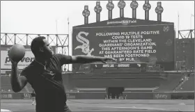  ?? CHARLES REX ARBOGAST/AP ?? CLEVELAND GUARDIANS’ FRANMIL REYES throws a football to teammate Myles Straw as the scoreboard informs fans that the game between the Chicago White Sox and the Guardians has been postponed due to multiple positive COVID-19 tests within the Guardians organizati­on on Wednesday in Chicago.