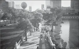  ?? JOHN LOCHER/AP ?? People walk Thursday along the Las Vegas Strip. Tourism is the city’s economic engine.