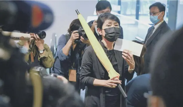 ??  ?? 0 Pro-democracy politician Claudia Mo holds a yellow umbrella and her resignatio­n letter at the Legislativ­e Council in Hong Kong