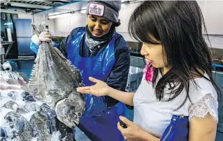  ??  ?? Above: Montreal writer Kim Thúy and worker Mariam Idle look over a halibut at Poissonner­ie La Mer, an indoor markete. Below: Thuy loves the rainbow at Church of Saint-Pierre-Apôtre in the Gay Village, below.