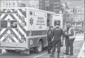  ?? ?? Two Philadelph­ia Transit Policeman are seen by a Philadelph­ia Fire Department Emergency Medical Services ambulance.