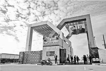  ??  ?? Portraits of Fattah al-Sisi and Abbas hang at the Rafah border crossing with Egypt. — AFP photo