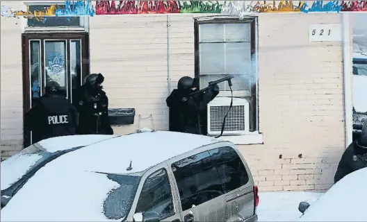  ?? RENE JOHNSTON / GETTY ?? Guerra. Un grupo especial de la policía de Toronto lanza una bomba de humo en el interior de una casa en la que
ha habido disparos