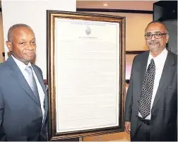  ??  ?? Dr Geoffrey Williams (left) with the citation presented to him by Dr Delroy Fray.