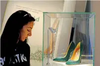  ??  ?? A woman takes a look at Emerald Green heels from Bobby’s brilliant heels by Brian Atwood at the exhibition.