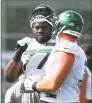  ?? Mike Stobe / Getty Images ?? Jets rookie Mekhi Becton (77) talks with a teammate at Atlantic Health Jets Training Center on Friday in Florham Park, N.J.