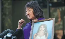  ?? THE CANADIAN PRESS ?? Carol Todd holds a photo of her late daughter Amanda Todd, who died by suicide in 2012, and the necklace she was wearing in the school photo outside B.C. Supreme Court after sentencing for the Dutchman accused of extorting and harassing her daughter, in New Westminste­r, in October 2022.