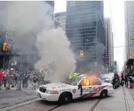  ?? CHRIS YOUNG / THE CANADIAN PRESS ?? A police car burns after G20 summit protesters set fire to it in downtown Toronto in 2010. A man has launched a civil suit alleging wrongful detention at a park.