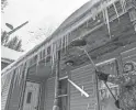  ??  ?? Ha Thao of Wausau, Wis., chips icicles off his porch Tuesday. Several inches of snow fell overnight.