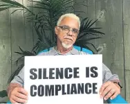  ?? COURTESY OF DOUG JOHNSON ?? Doug Johnson of London, Ont., sits in his backyard with the sign he carried in the Black Lives Matter march in that city on June 6.