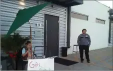  ??  ?? Lexi Menees, 8, sells Girl Scout Cookies while sitting outside Trumed Dispensary, which sells medical marijuana for licensed patients, in Phoenix on Friday.