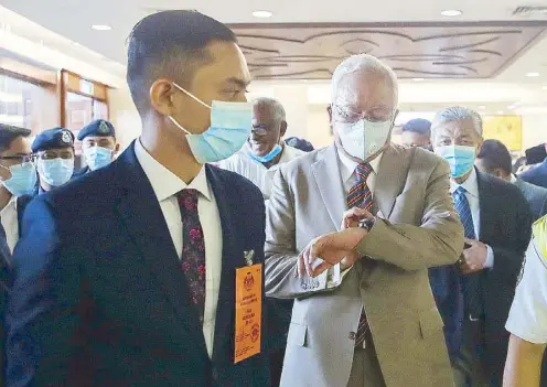  ?? AFP ?? Former Malaysian prime minister Najib Razak (center) arrives at the Kuala Lumpur High Court complex for the verdict on his corruption trial yesterday.