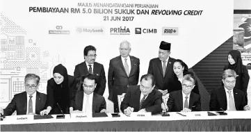  ??  ?? Najib (standing centre) witnessing the signing ceremony between the four banks and PR1MA at the Bangunan Perdana Putra, in Putrajaya yesterday. — Bernama photo