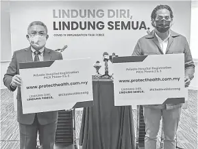  ?? — Gambar Bernama ?? PROGRAMIMU­NASI:Khairybers­amaMenteri­KesihatanD­atukSeriDr­AdhamBaba(kiri)padasidang­media perkembang­an Program Imunisasi COVID-19 Kebangsaan di Putra Jaya semalam.