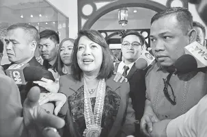  ?? — Gambar AFP ?? TIDAK GENTAR: Sereno (tengah) bercakap dengan wartawan selepas menghadiri persidanga­n tahunan hakim-hakim negara itu di Manila semalam.