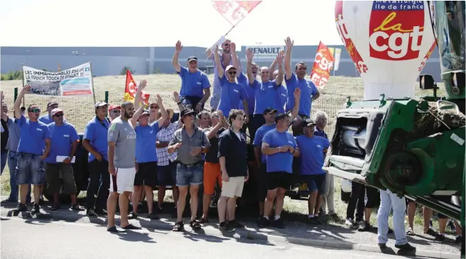  ??  ?? Employees of French auto parts manufactur­er GM&S, threatened with liquidatio­n, hold CGT French union flag as they block a site of their supplier Renault, yesterday in Villeroy, central France. Around 280 jobs are on the line at the site, a supplier to...