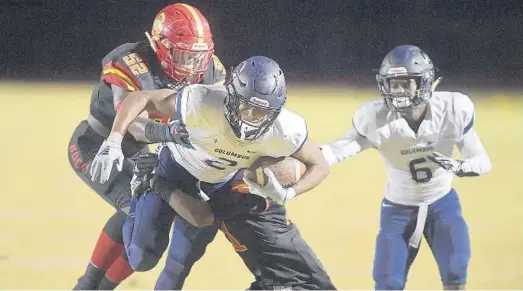  ?? MICHAEL LAUGHLIN/SUN SENTINEL ?? Friday’s scores Miami Columbus receiver Kalani Norris is tackled by a couple of Deerfield Beach players during the first half of their game Friday. For coverage of Friday’s games, see