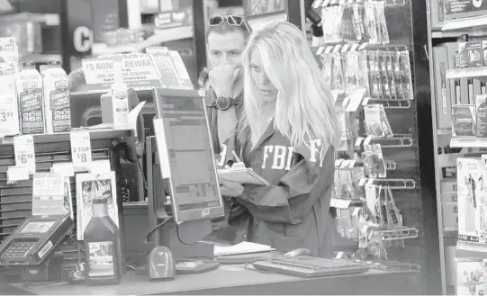  ?? AMY BETH BENNETT/SOUTH FLORIDA SUN SENTINEL ?? An FBI agent examines a computer at the AutoZone store on State Road 7 in Plantation where Cesar Sayoc Jr., 56, of Aventura, was arrested Friday.